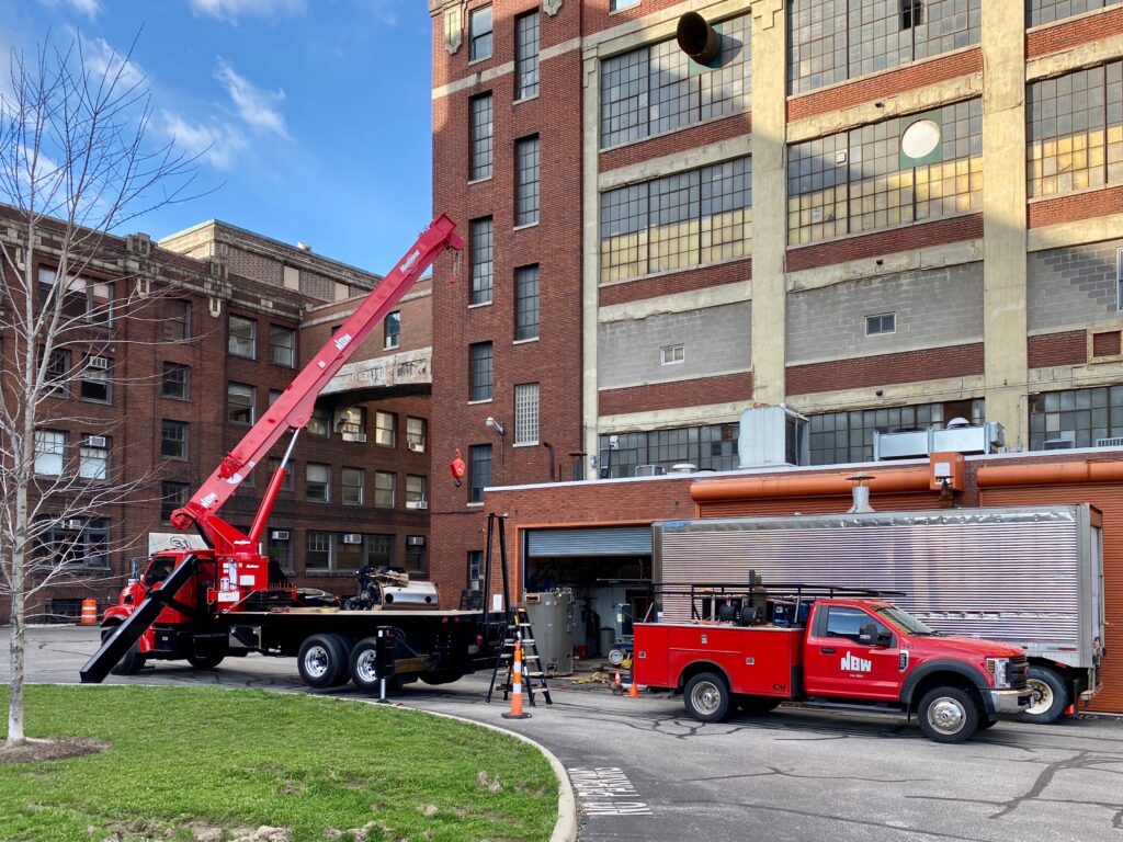 Two red trucks outside of a building. NBW Inc.