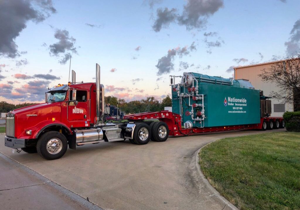 A red NBW truck driving a Nationwide Boiler. NBW Inc.