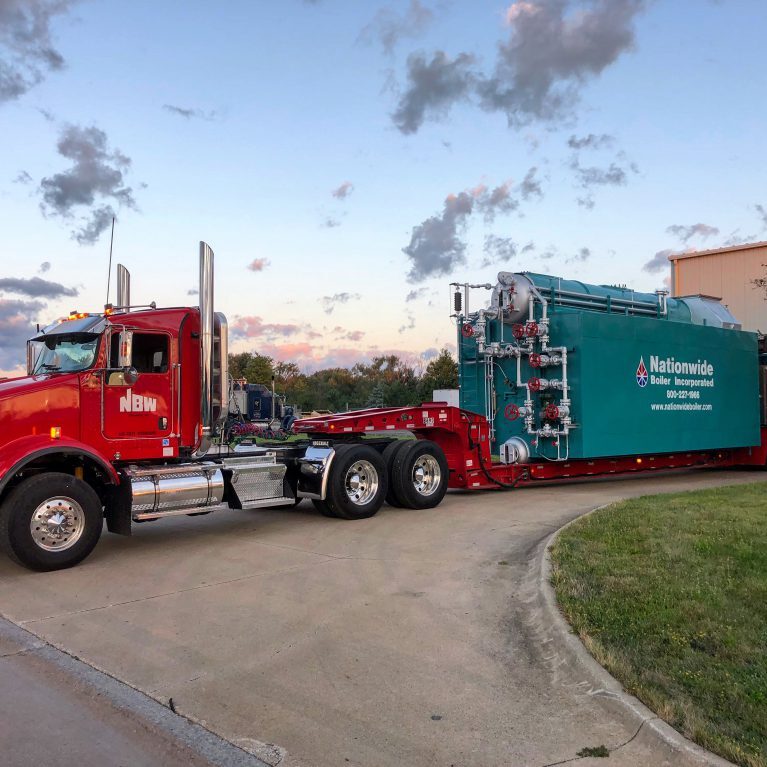 A red NBW truck driving a Nationwide Boiler. NBW Inc.